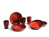 un ensemble d'assiettes et de tasses rouges posées sur une surface blanche