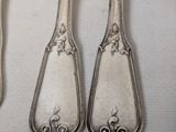 three spoons and a fork are sitting on a table