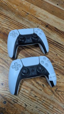 deux manettes de jeux vidéo posées sur une table en bois