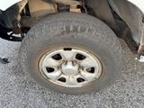 a white truck that has a flat tire on the side of it