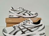 a pair of white and black running shoes on a box