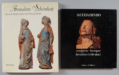 deux livres posés sur une table, à côté d'une statue représentant un homme et une femme