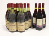 six bottles of wine are lined up in a row on a white surface