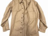 une veste beige avec des boutons sur la poitrine et un col boutonné