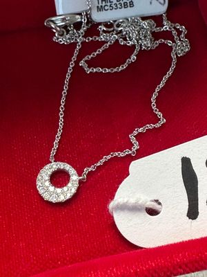 un collier en argent avec un anneau, présenté dans une boîte rouge