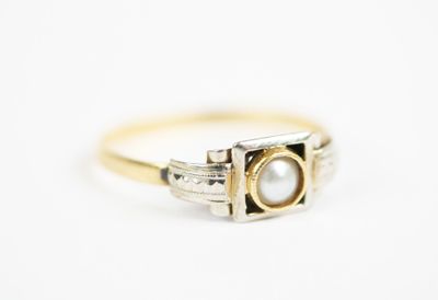 a close up of a gold ring with a pearl in it