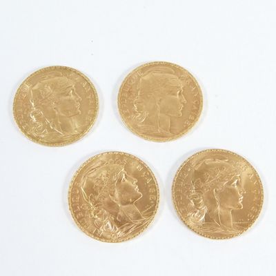 quatre souverains d'or posés sur une surface blanche, sur fond blanc