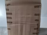 a large cardboard box sitting on the floor next to a bed