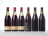 six bottles of wine lined up in a row on a table