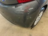 the rear end of a gray car with a sticker on it ' s bumper