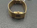 a close up of a gold watch on a black surface