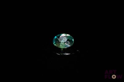 gros plan d'un diamant vert sur une surface noire