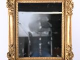 a picture of a gold framed mirror on the wall