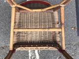 a wicker chair sitting on the side of the road