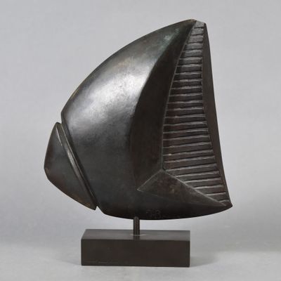 bronze sculpture of a boat on a stand on a gray background