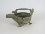 a small metal animal shaped pot on a white surface