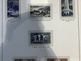 a shadow of a person holding a cell phone in front of a picture of stamps
