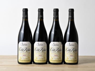 trois bouteilles de vin sont alignées sur une table en bois