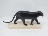 statue of a black cat on a marble base on a white background