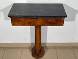 a small table with a black top on a tiled floor
