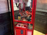 a red vending machine sitting on the floor