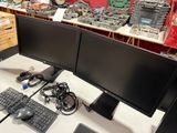 two computer monitors sitting on a desk next to a keyboard and mouse