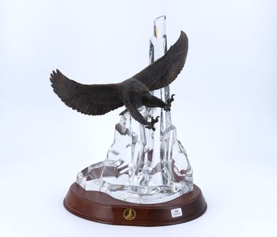 une image représentant une statue d'aigle planant au-dessus d'une montagne