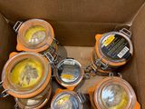 de nombreux bocaux de conserve dans un carton posé par terre