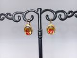 a close up of a pair of earrings on a stand