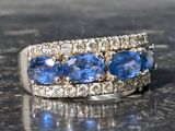 a close up of a ring with blue sapphires and diamonds