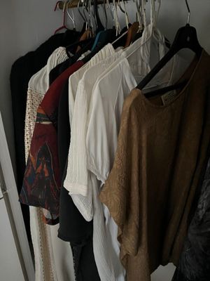 a lot of clothes hanging on a rack in a closet