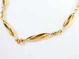 a close up of a gold necklace on a white surface