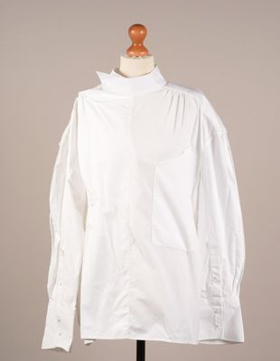 une photo d'une chemise blanche posée sur un présentoir pour mannequin