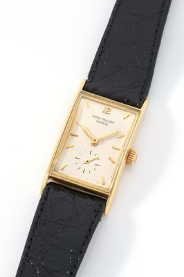 a close up of a watch on a black strap on a white surface
