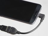 a cell phone connected to a usb cable on a table