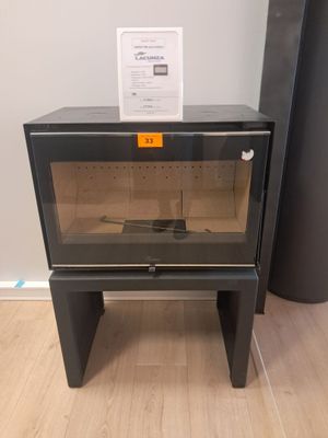 une petite armoire noire avec une porte vitrée, à côté d'un grand vase noir