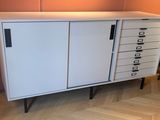 une armoire blanche à tiroirs et une chaise dans un coin