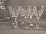 six wine glasses and a decanter on the table