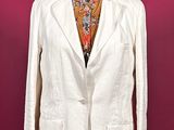 a white jacket on a mannequin stand against a red wall