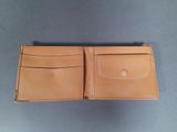 a brown leather wallet sitting on top of a table