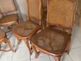 quatre chaises en bois et une table dans une pièce au sol carrelé