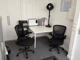 un bureau avec deux chaises et un ordinateur dessus