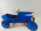 an old fashioned toy car with blue wheels and a steering wheel