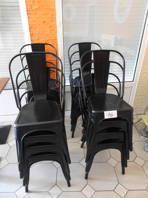quatre chaises en métal noir placées devant une fenêtre