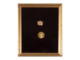une image encadrée d'or représentant une couronne et une pièce de monnaie