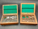 two wooden boxes with coins inside of them on a table