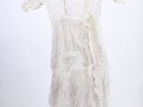 the white dress is hanging on a hanger in the room