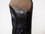 heel of a pair of black leather boots with holes in the sole