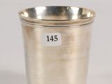 an antique silver cup with a label on the side of it