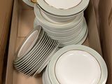 beaucoup d'assiettes dans une boîte posée par terre